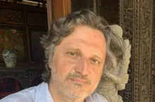 Adrian Constantinescu, Porträt vor grünem Laub, im hellen Leinenhemd
